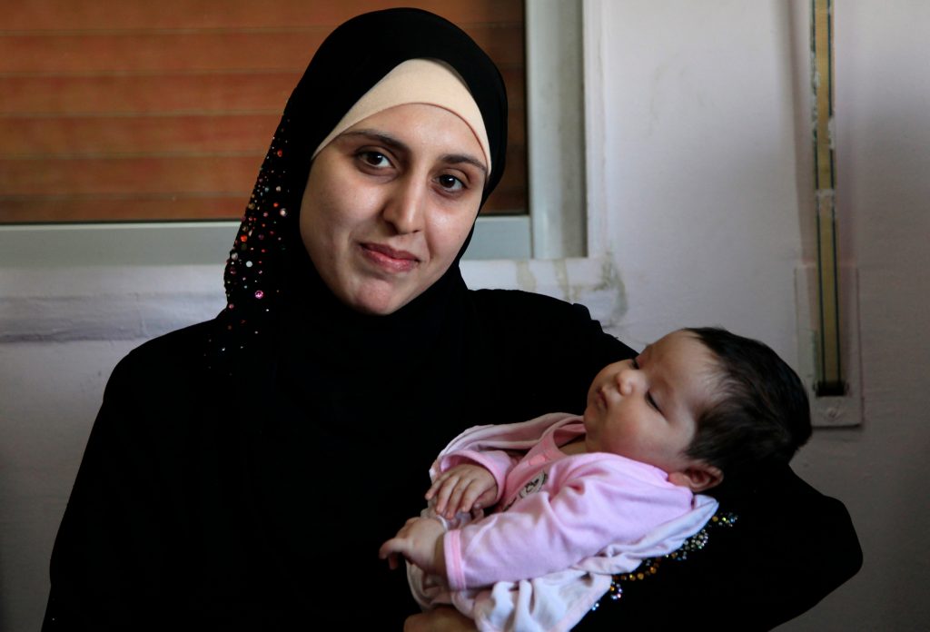 a_syrian_refugee_and_her_newborn_baby_at_a_clinic_in_ramtha_jordan_9613483141